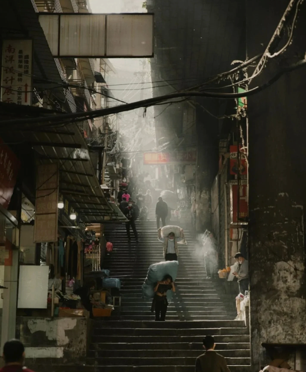 Workers carrying goods up a steep Chongqing stairway