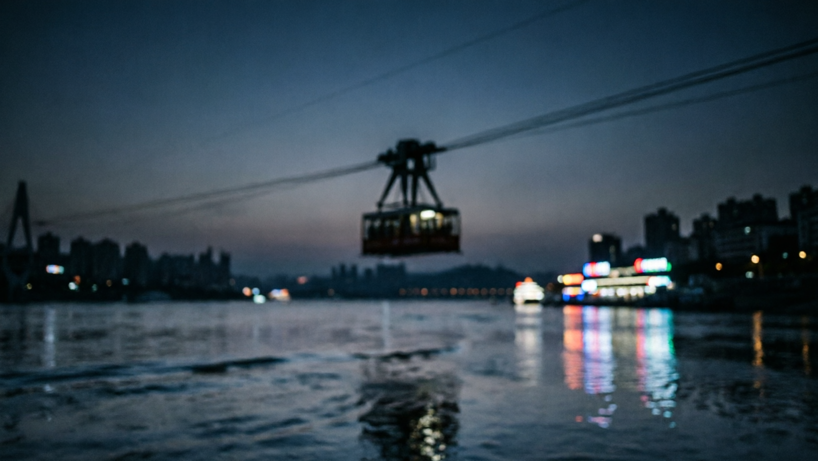 A Chongqing cable car crossing the layered city at night